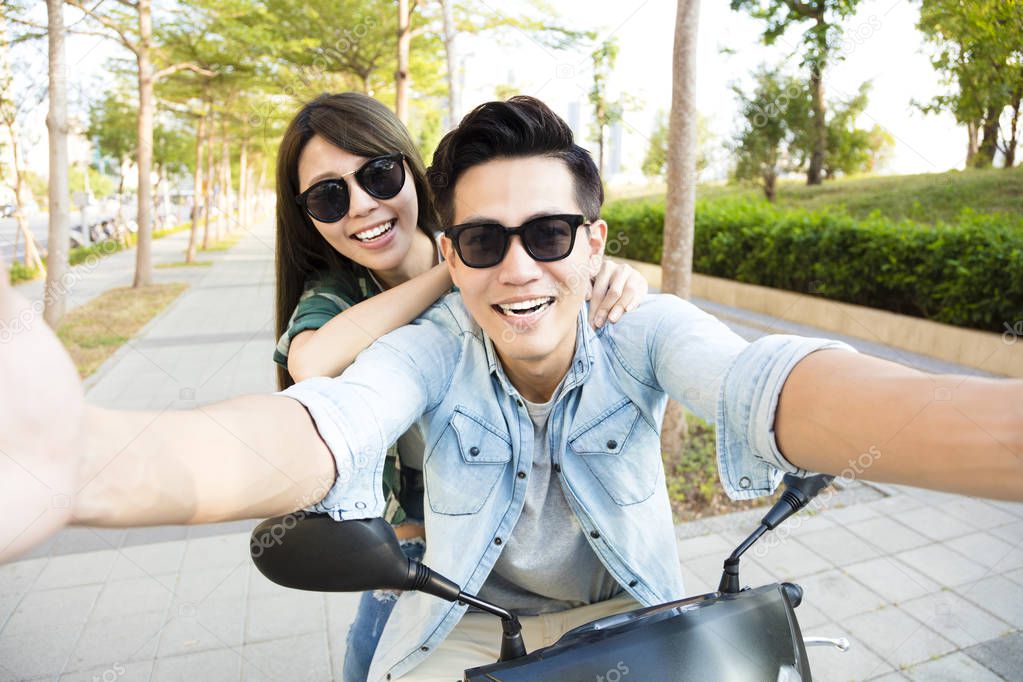 Selfie di gruppo con moto parcheggiate sullo sfondo